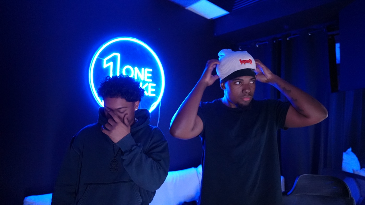 Two artists in the lounge under the neon sign
