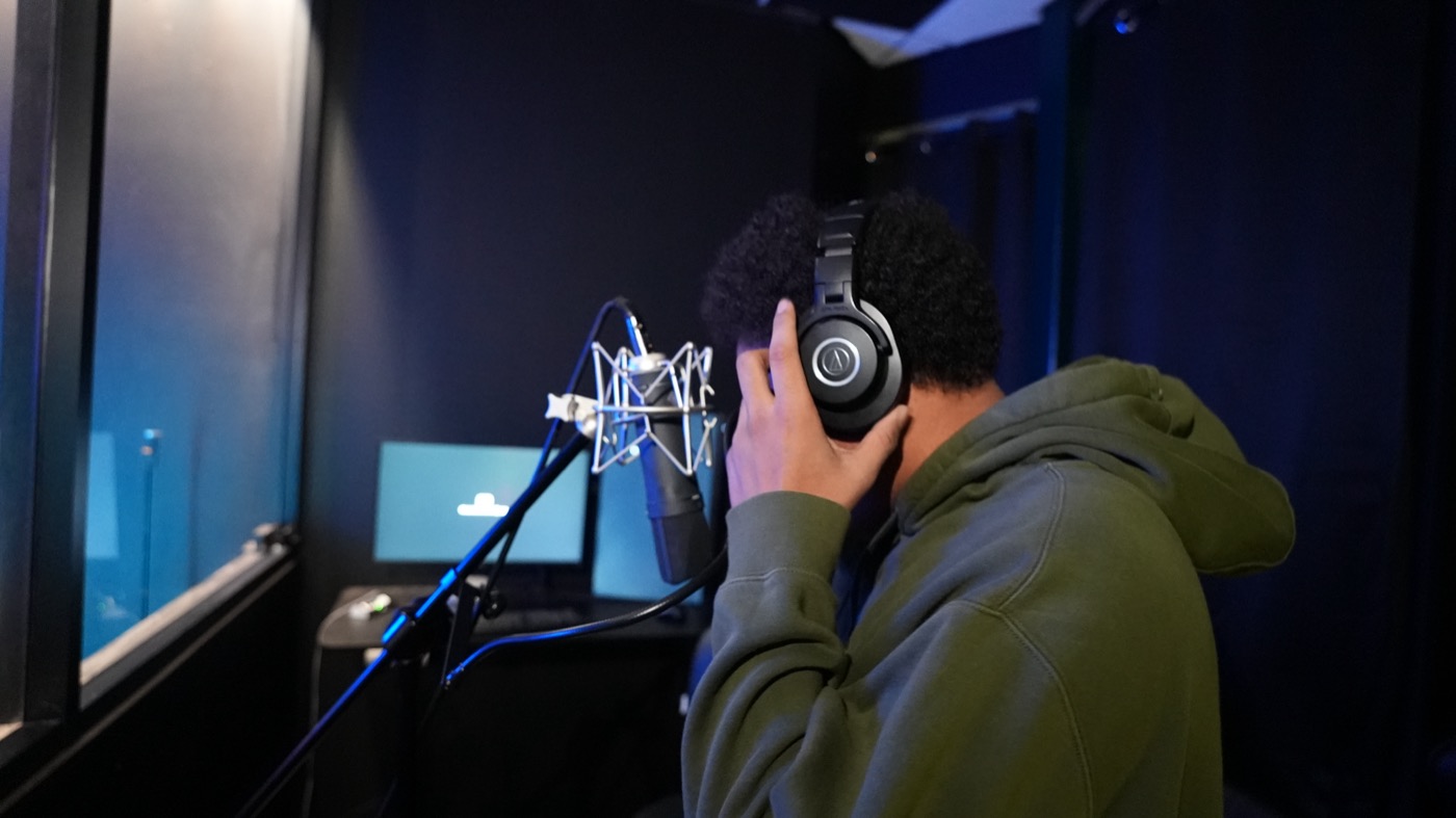 Artist adjusting headphones at the microphone