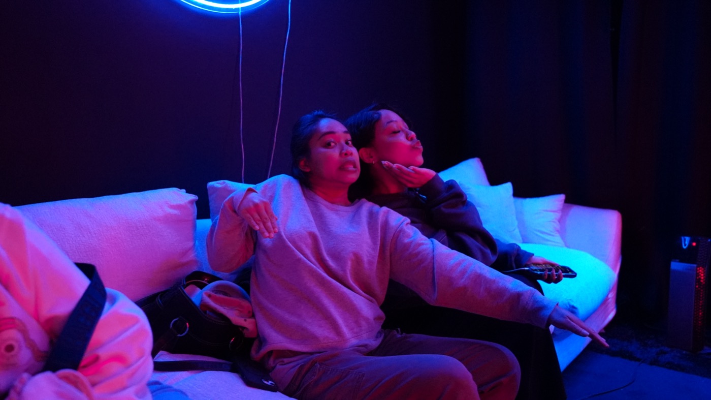 Two guests relaxing on the couch between takes